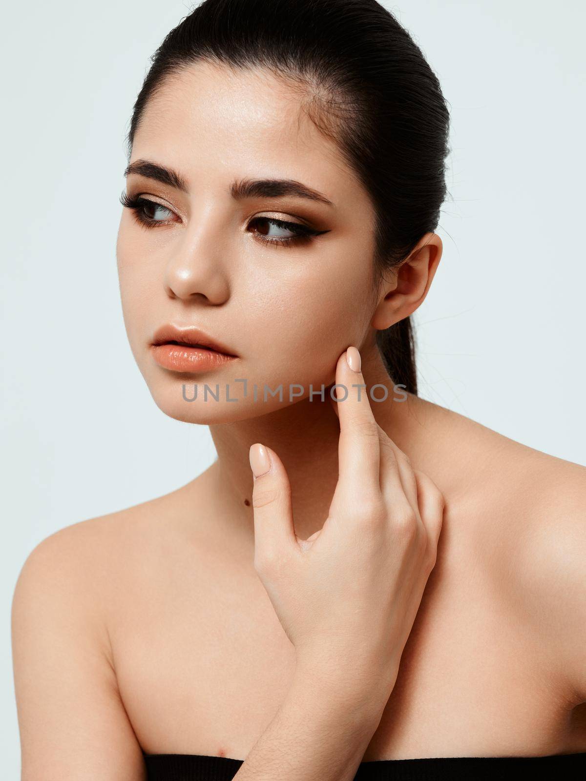 Woman in black dress nude adhesive makeup model hand near face. High quality photo