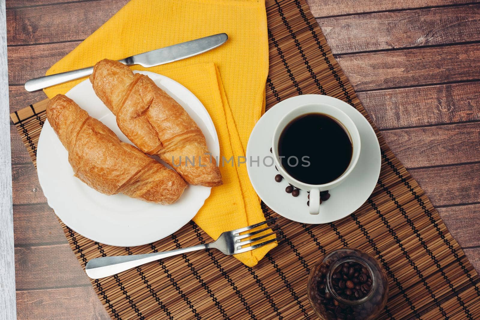 fresh croissants on a saucer table setting breakfast cup with drinks. High quality photo