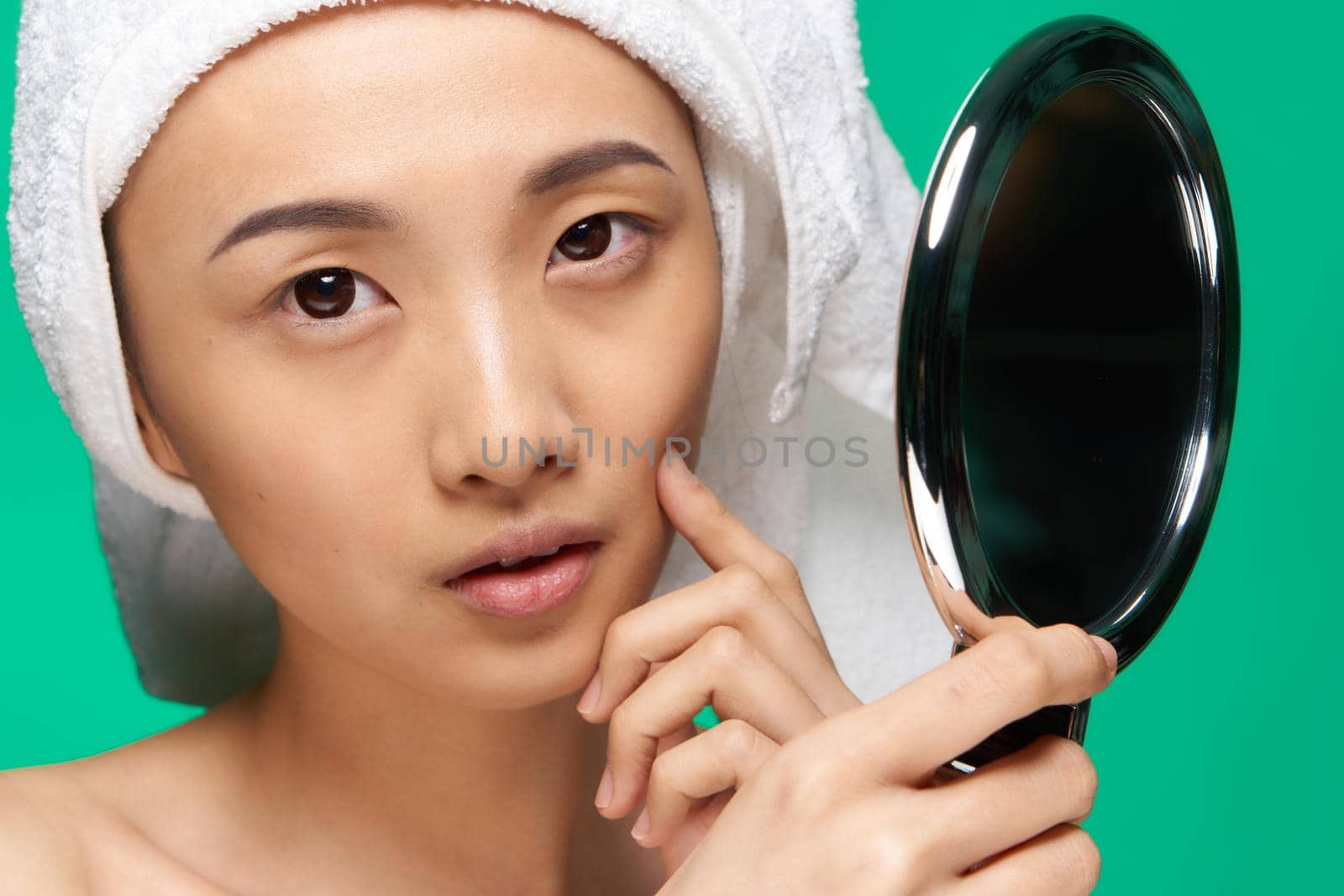 woman asian appearance face close up skin care mirror in hands. High quality photo