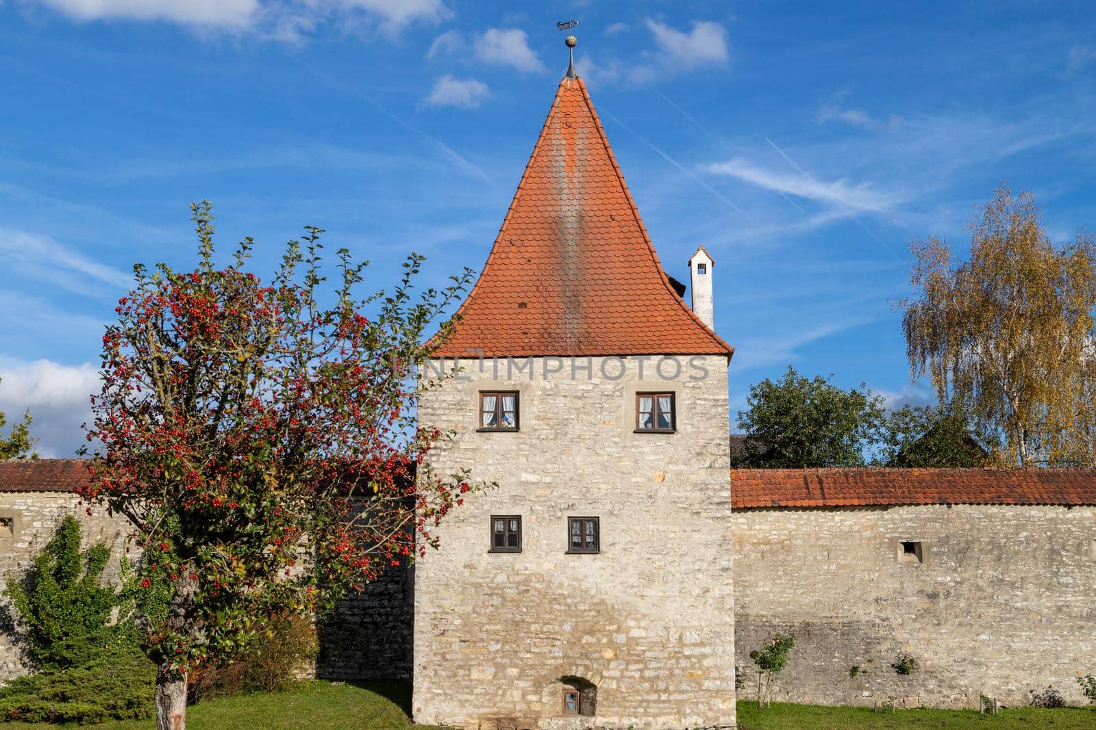 Autumn landscape with multicolored trees and city wall with tower in Berching, Bavaria on a sunny day