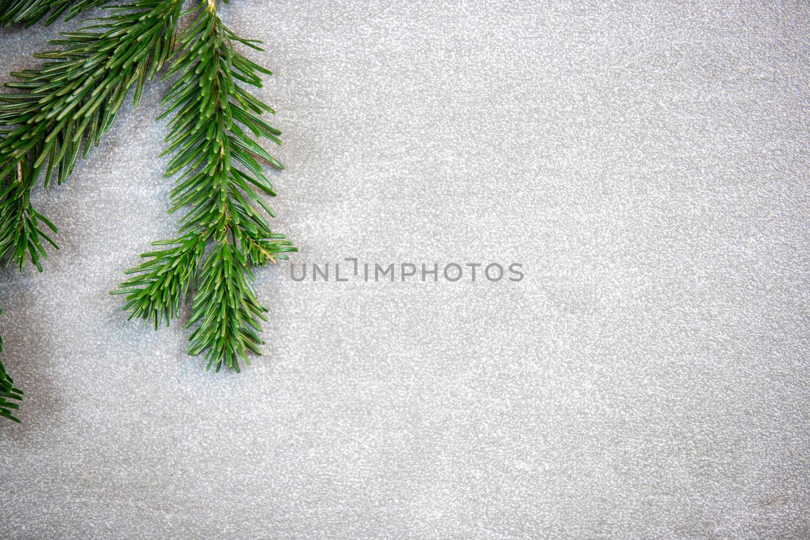 Christmas motif, texture, background with branches of a Nordmann fir left at the top on a grey marbled  background with free space for text