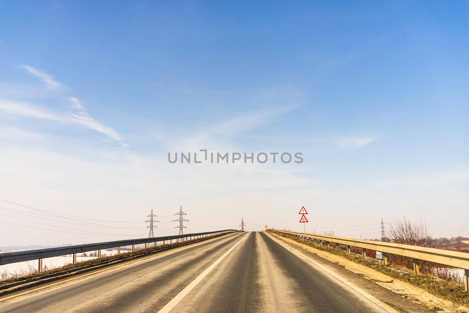 Winter season, view of cars and snowy street through windshield while driving in Bucharest, Romania, 2021.   by vladispas