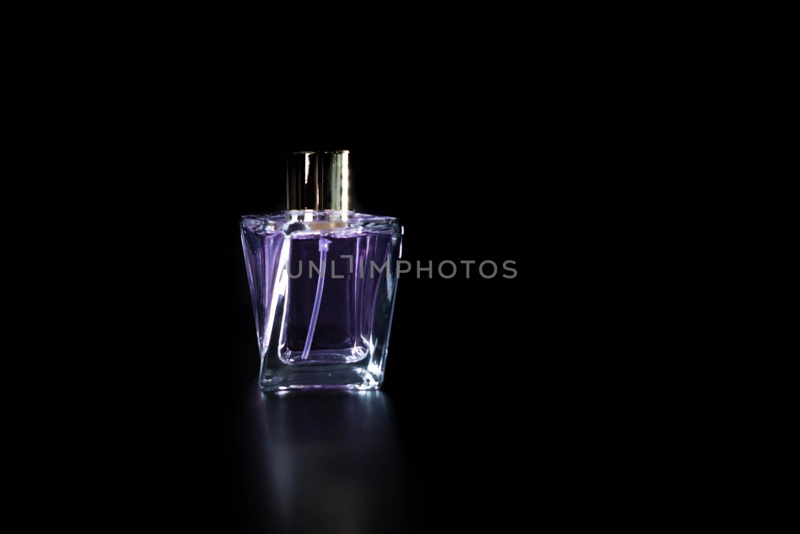 Elegant perfume bottle isolated on black background with copy space.