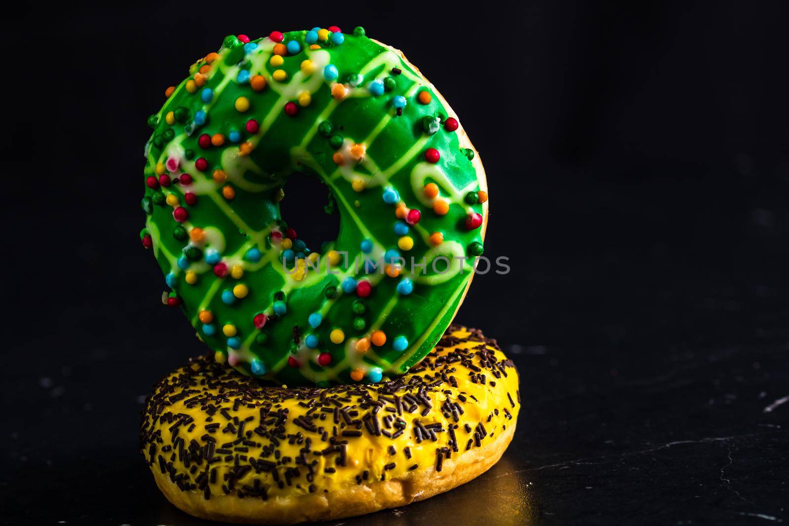 Glazed donuts with sprinkles isolated. Close up of colorful donuts.