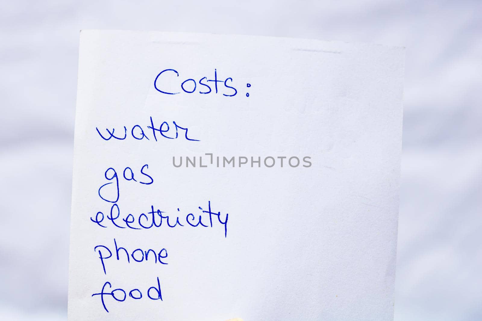 Costs handwriting text close up isolated on white paper with copy space. Writing text on memo post reminder