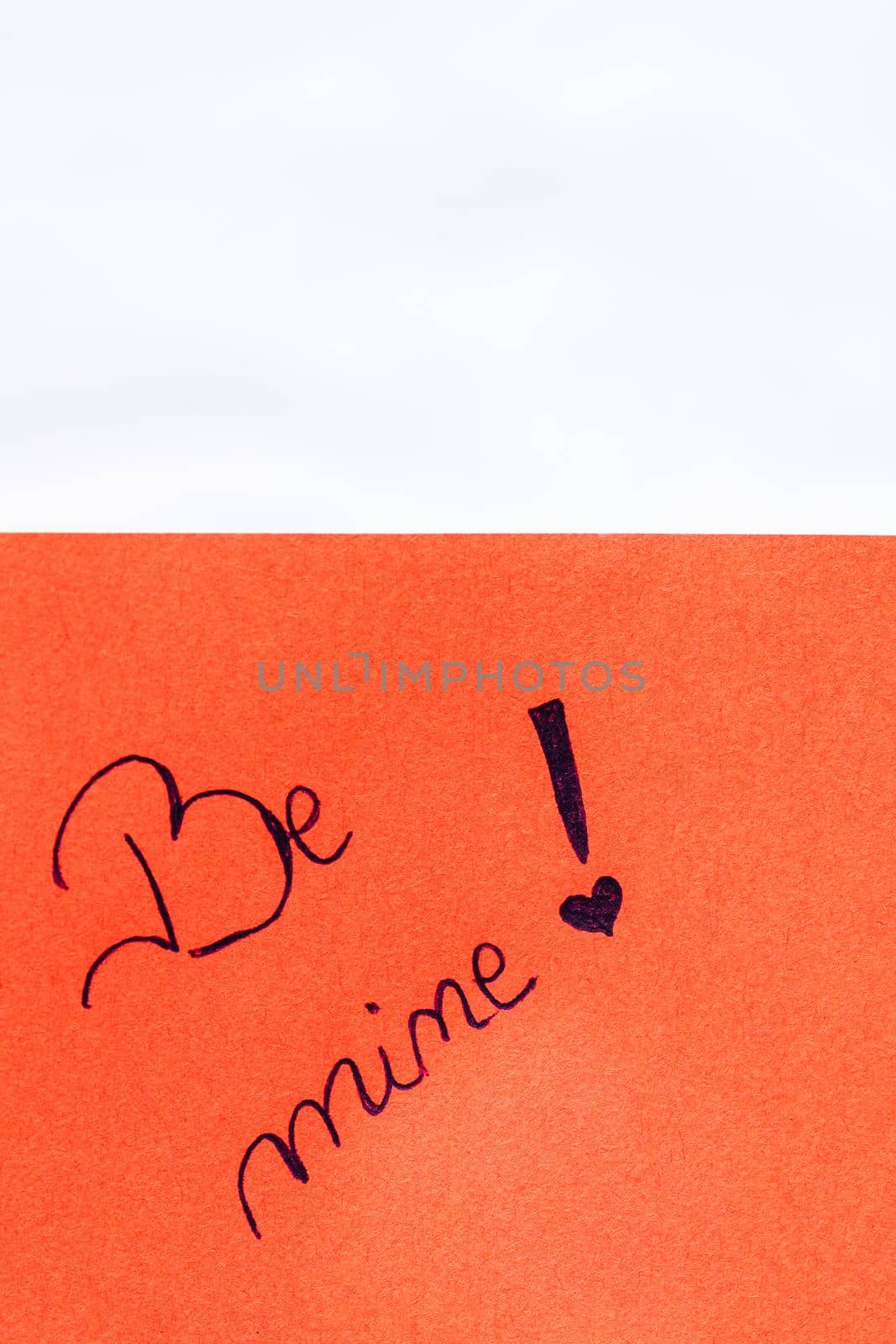 Be mine handwriting text close up isolated on orange paper with copy space. Writing text on memo post reminder