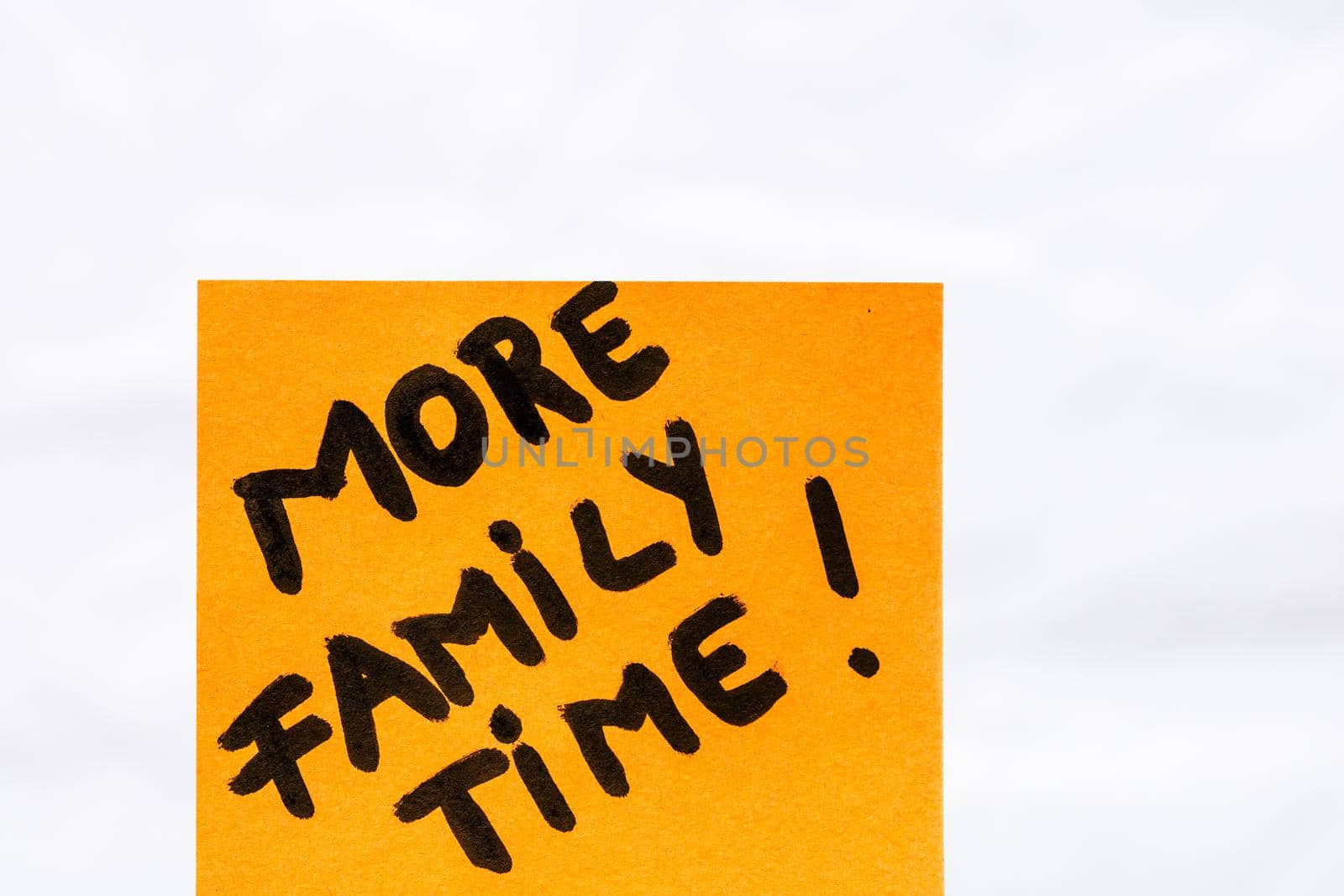 More family time handwriting text close up isolated on orange paper with copy space.