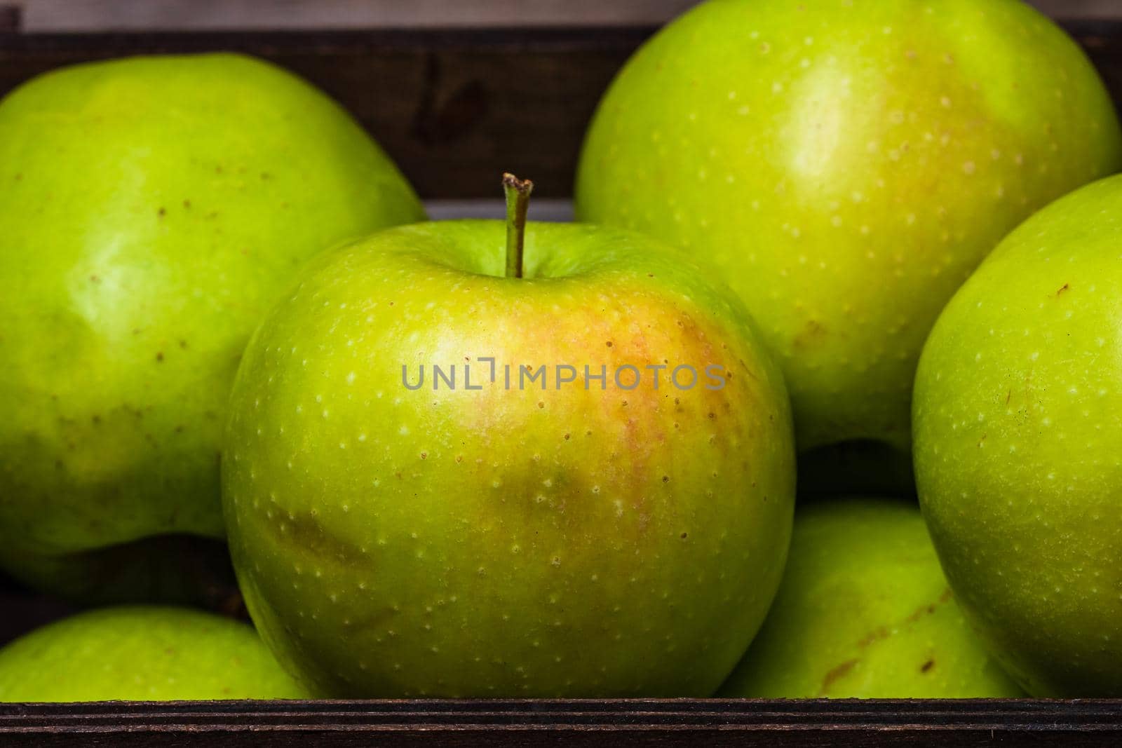 Ripe green apples in a wooden crate, close up isolated. by vladispas