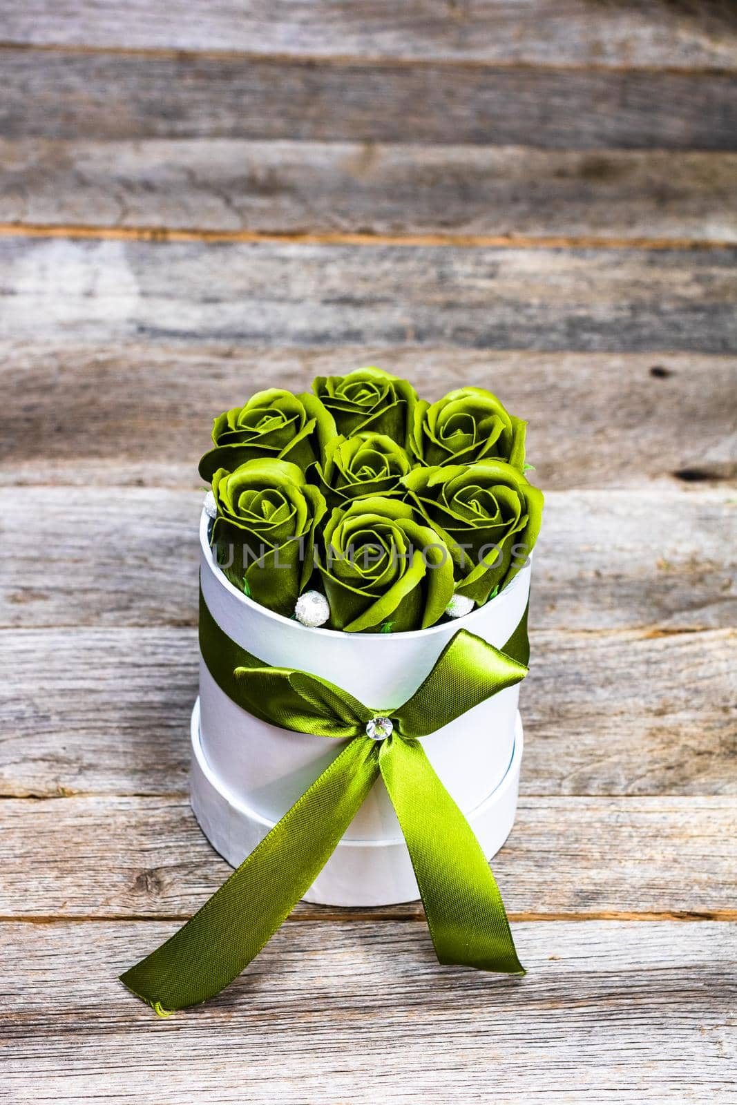 Green roses in a round luxury present box. Bouquet of flowers in a paper box isolated.