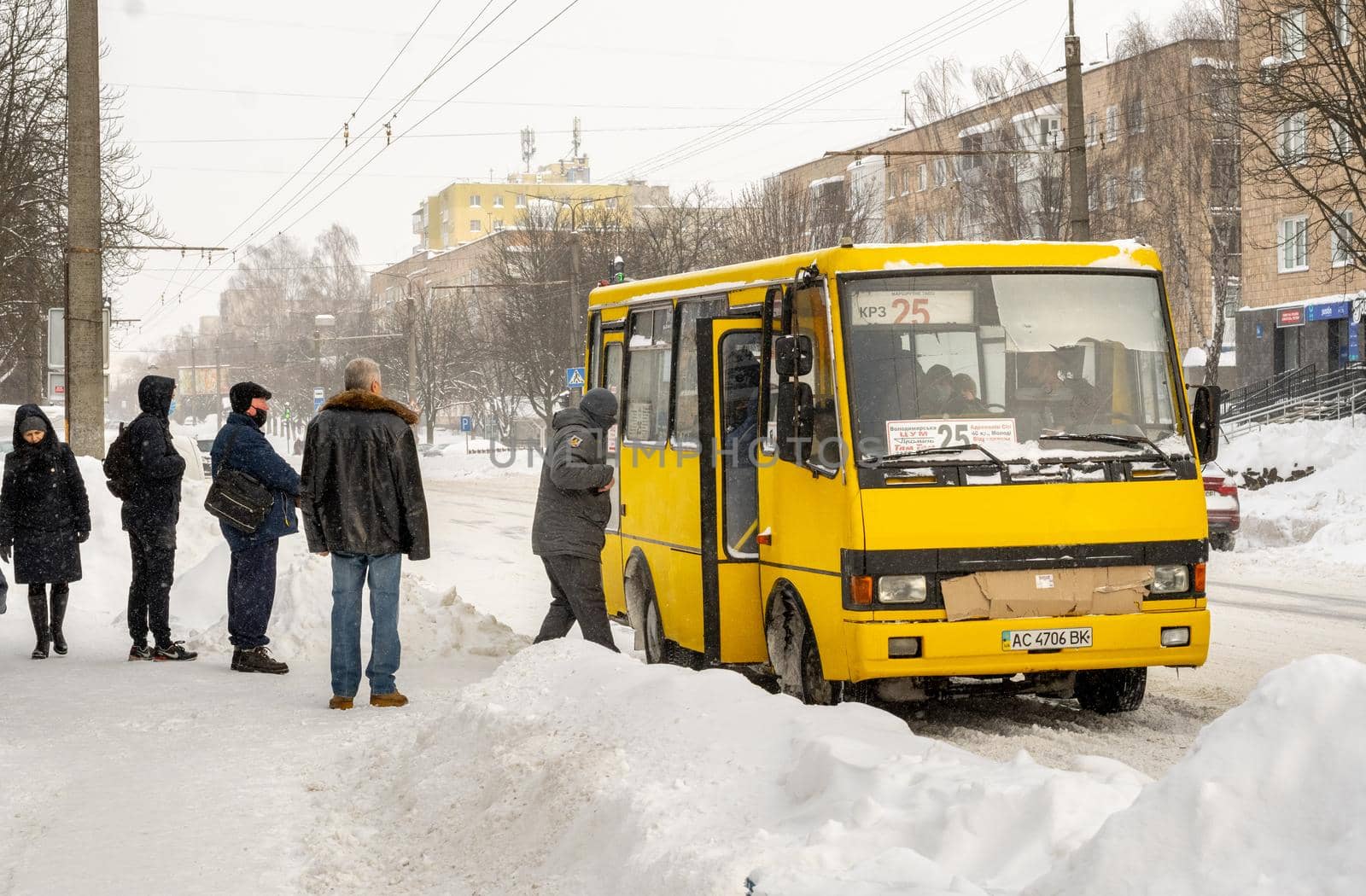 Lutsk, Ukraine - February 12,2020: People on street after snow storm. City street after blizzard. Record-breaking amounts of snow. Uncleaned slippery roads and sidewalk in winter. Cars in snowdrift