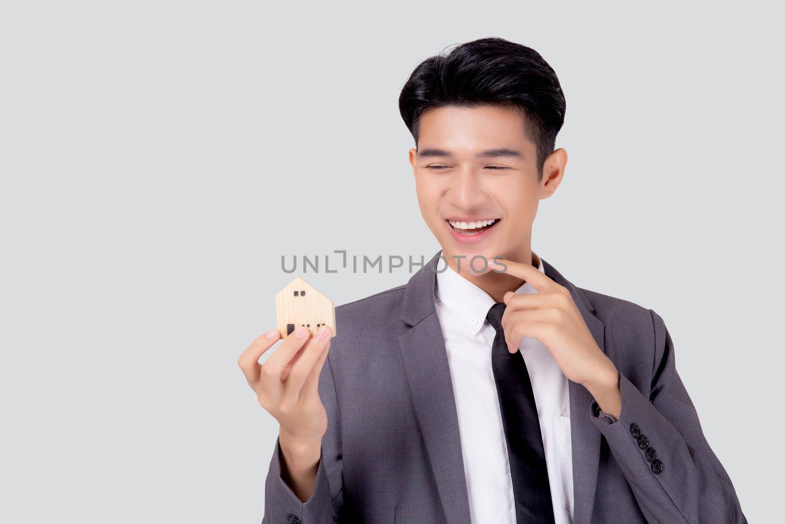 Young asian business man thinking idea and holding the home symbol of planning saving for future, insurance agent and credit, debt and loan of finance, home and refinance, investment real property.