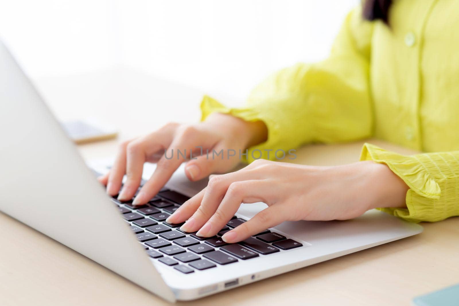 Closeup of hand young asian businesswoman working on laptop computer on desk at home office, freelance looking and typing on notebook on table, woman studying online, business and education concept.