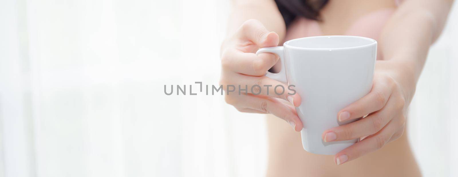 Closeup young asian sexy woman in underwear giving coffee near windows in the morning, girl with seductive figure fit serving beverage is breakfast for relax after wake up, lifestyle concept.