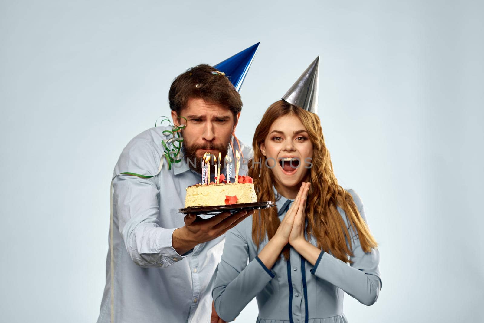 Emotional man with cake and pretty woman party disco blue background. High quality photo