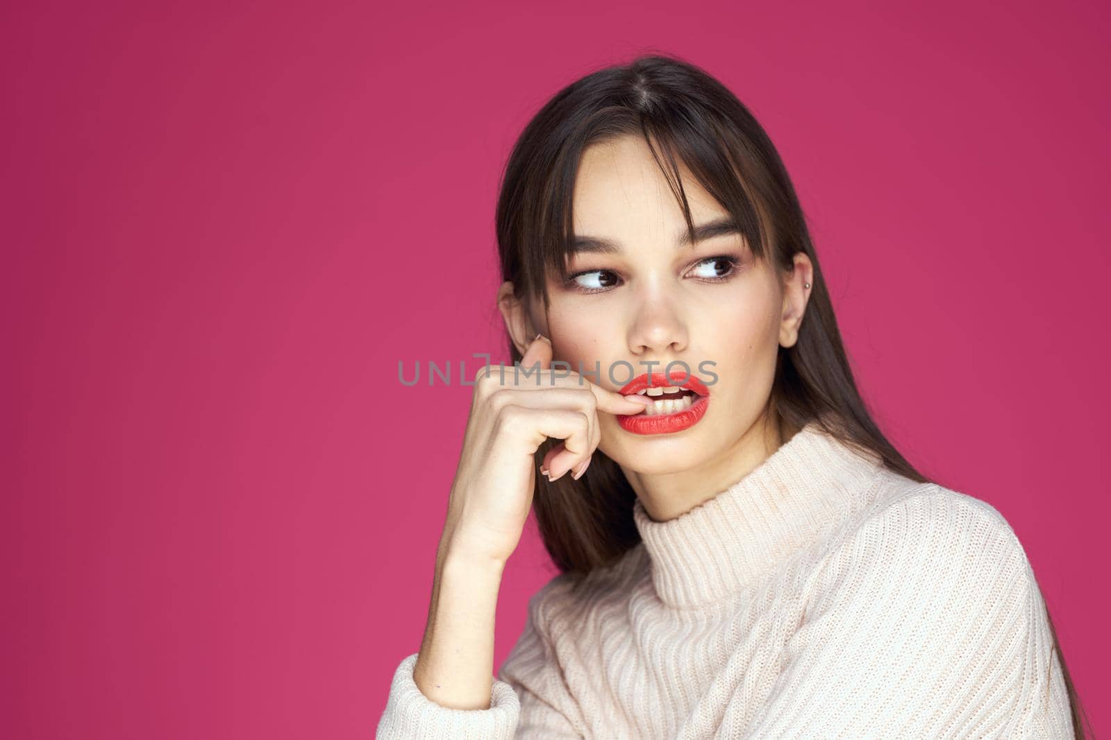 Woman with long hair and red lips white blouse pink background attractive look. High quality photo