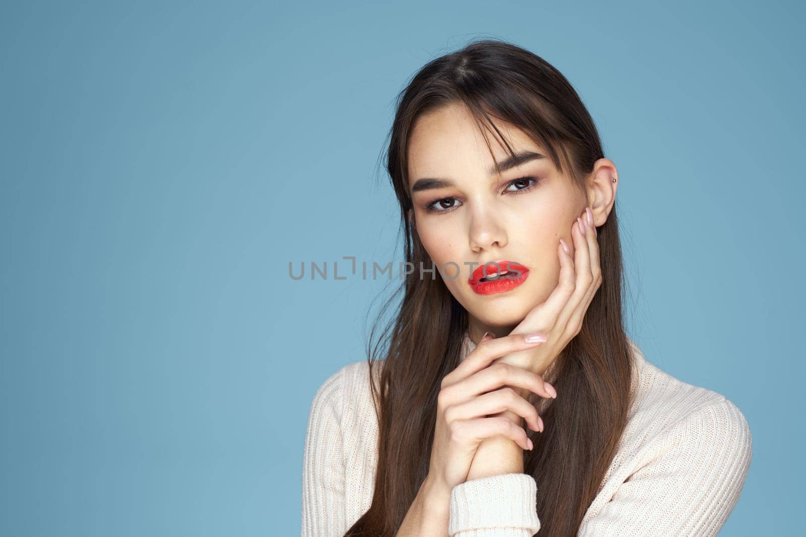 Brunette in white sweater red lips charm cropped view blue background. High quality photo