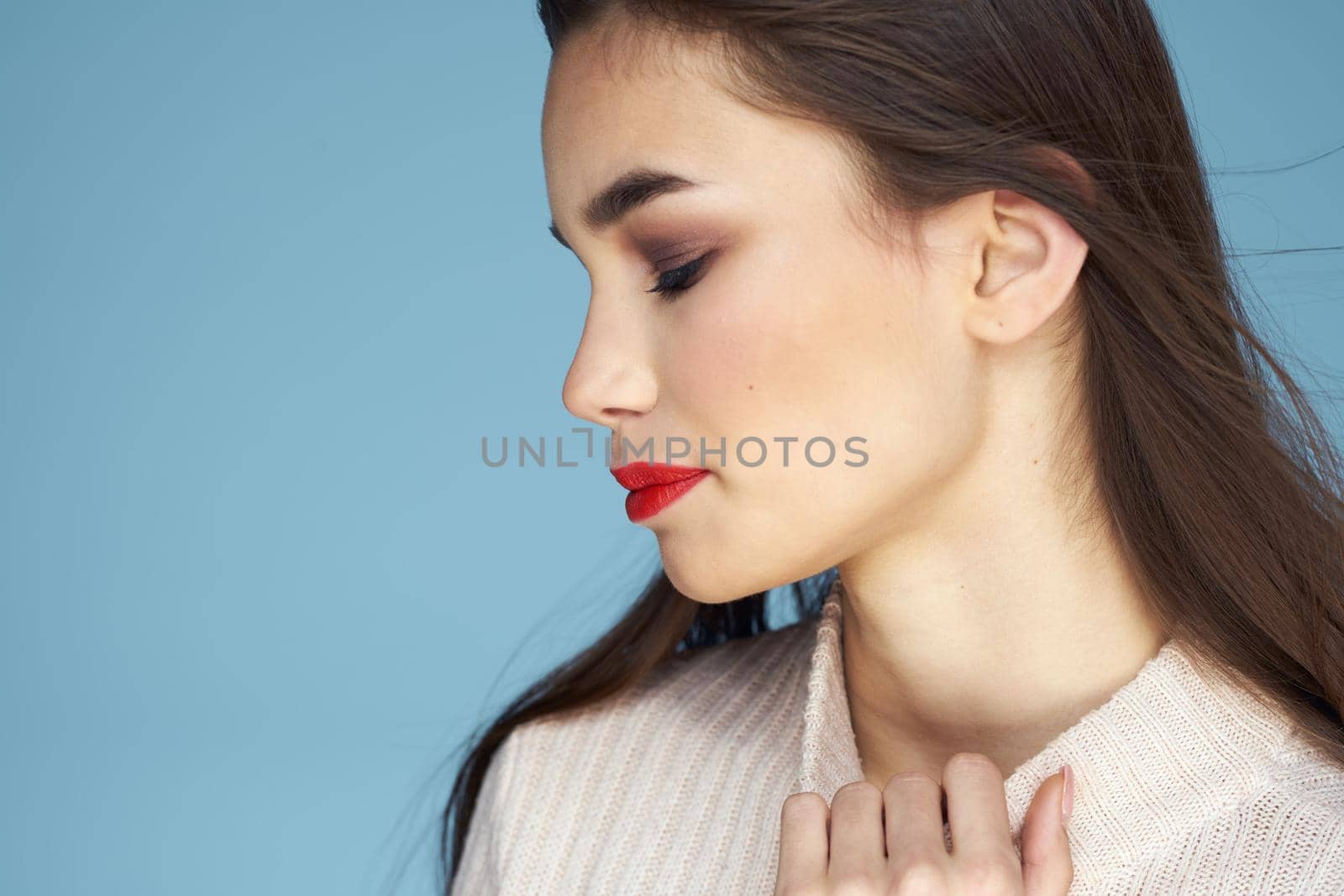 Pretty woman red lips white jacket attractive look close-up blue background. High quality photo