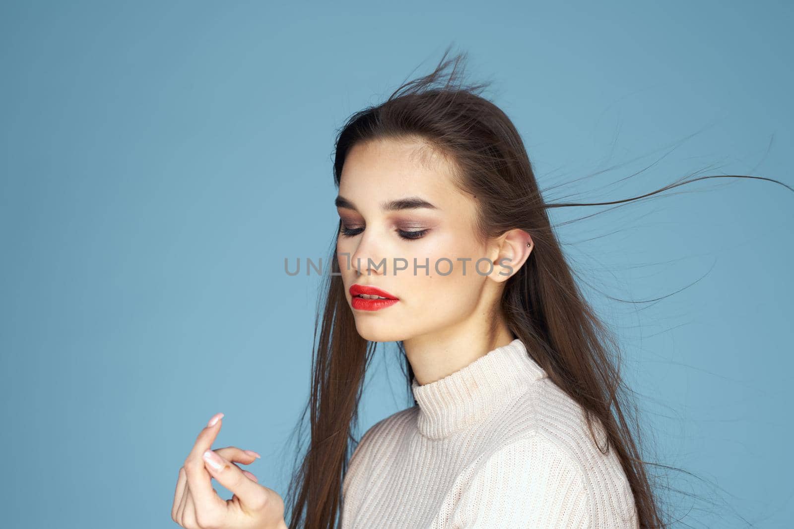 Pretty woman red lips white jacket attractive look close-up blue background. High quality photo