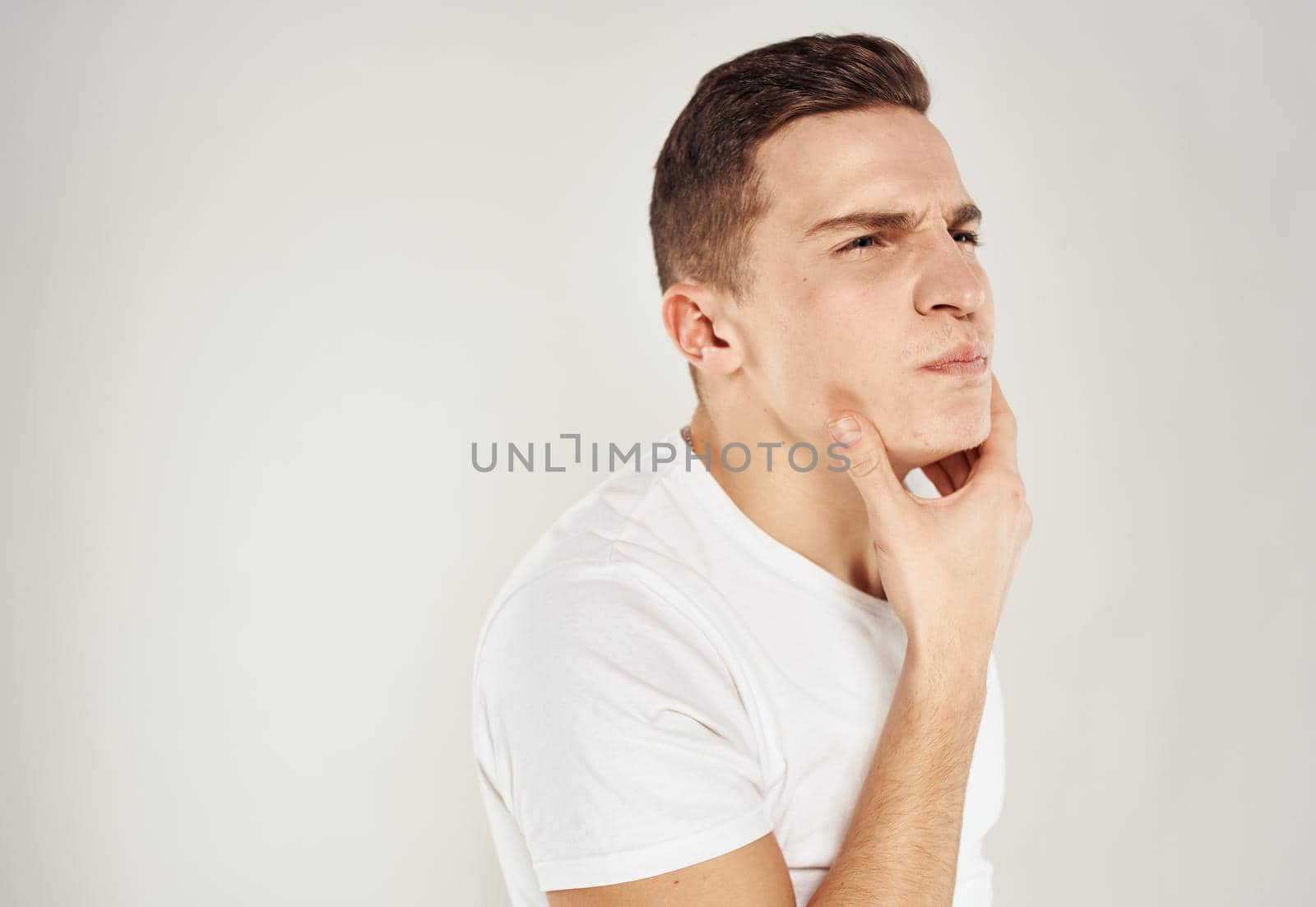 Male puzzled look face sleeves model white t-shirt. High quality photo