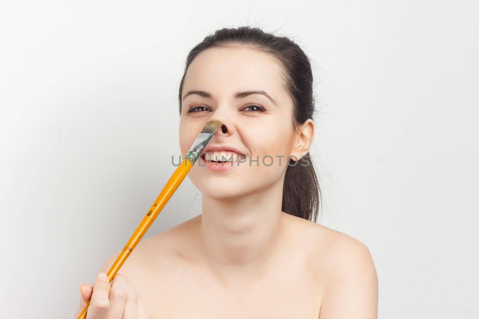 pretty woman with bare shoulders brush in hand skin care applying makeup. High quality photo