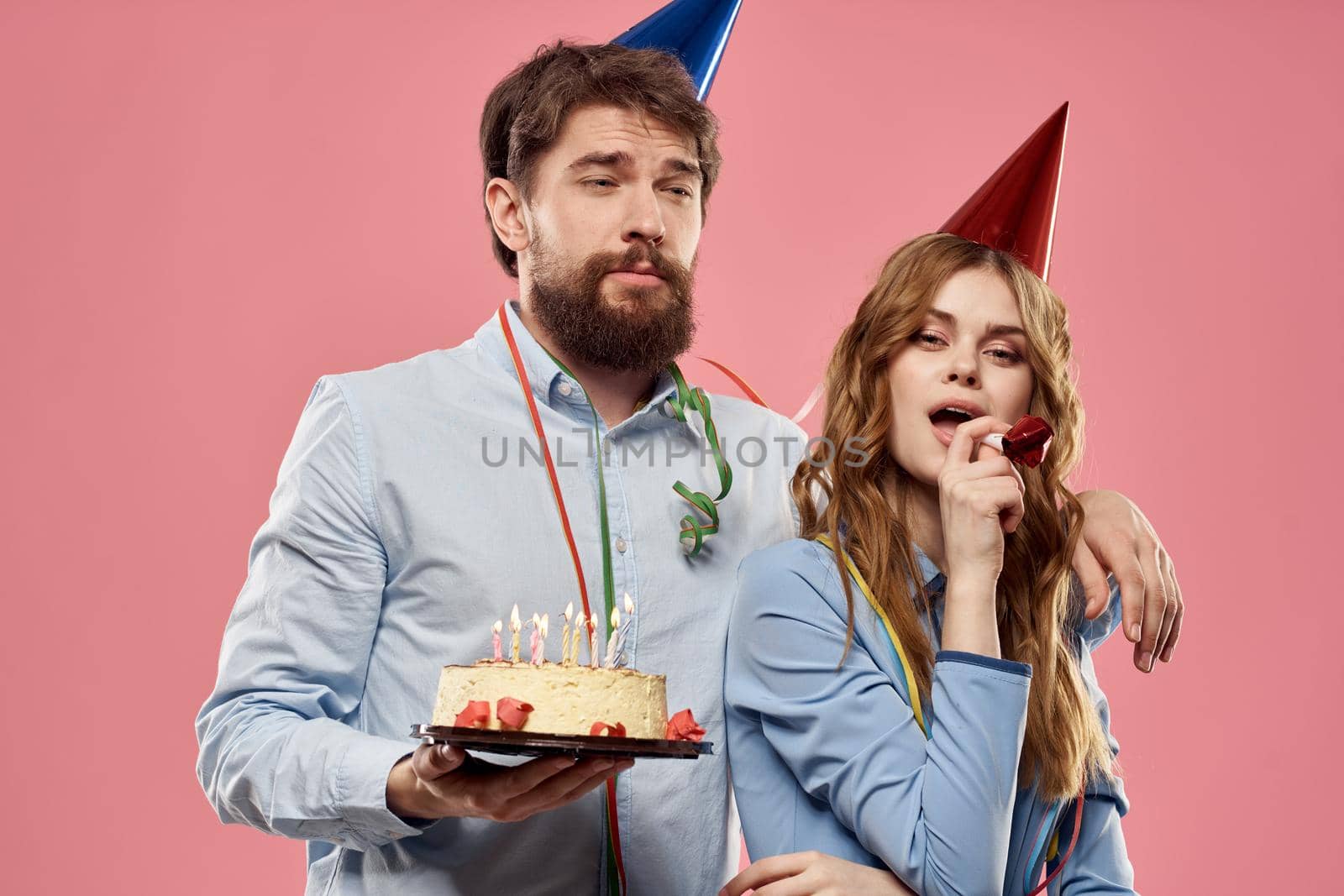 Party man and woman with cake on pink background corporate birthday. High quality photo