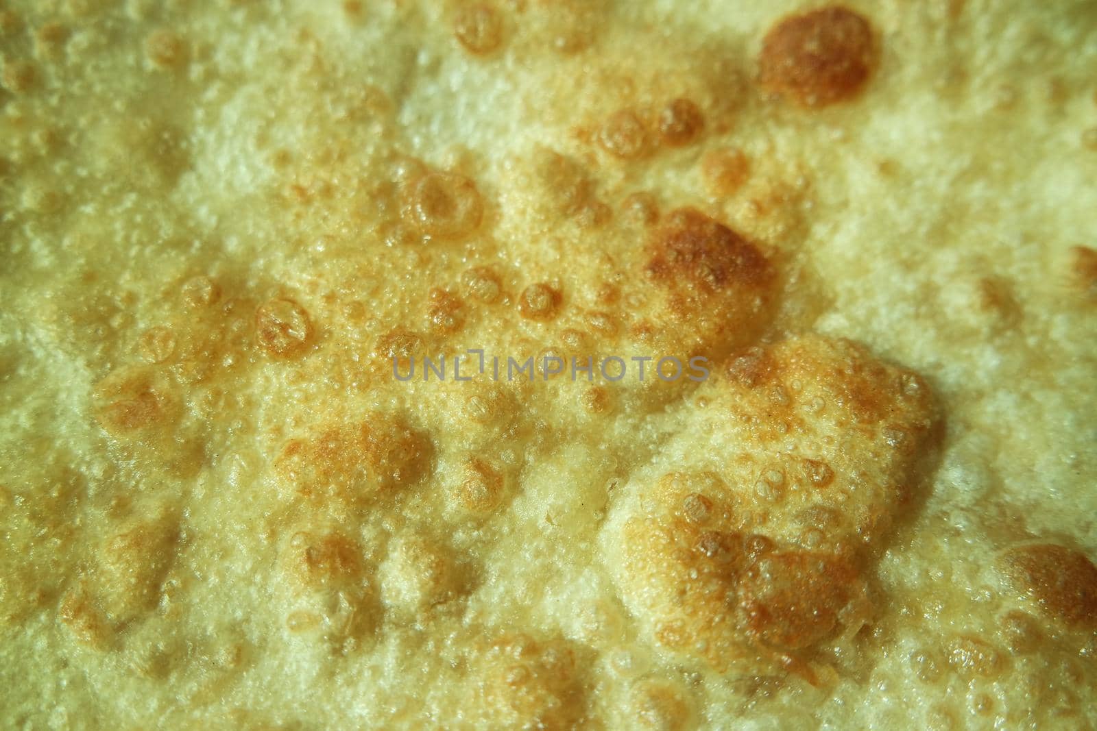 Closeup view of hand made plain bread in oil called paratha roti. by Photochowk