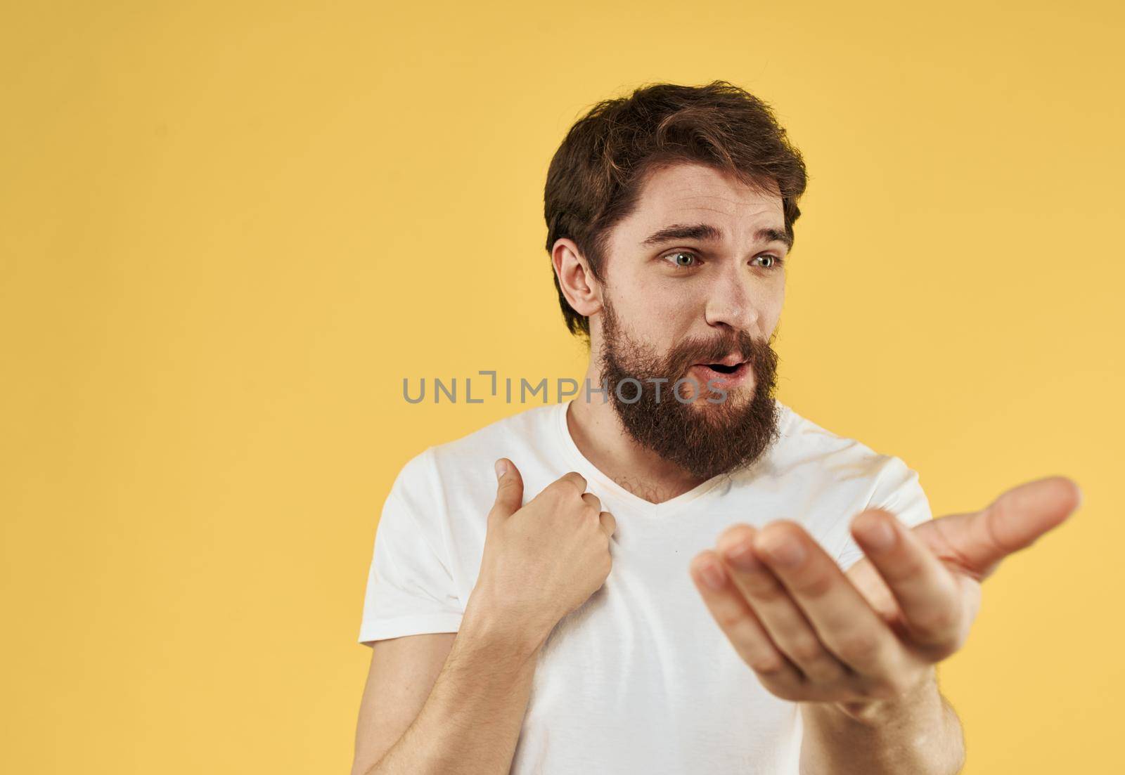 Man shows positive hand gesture emotions fun yellow background. High quality photo