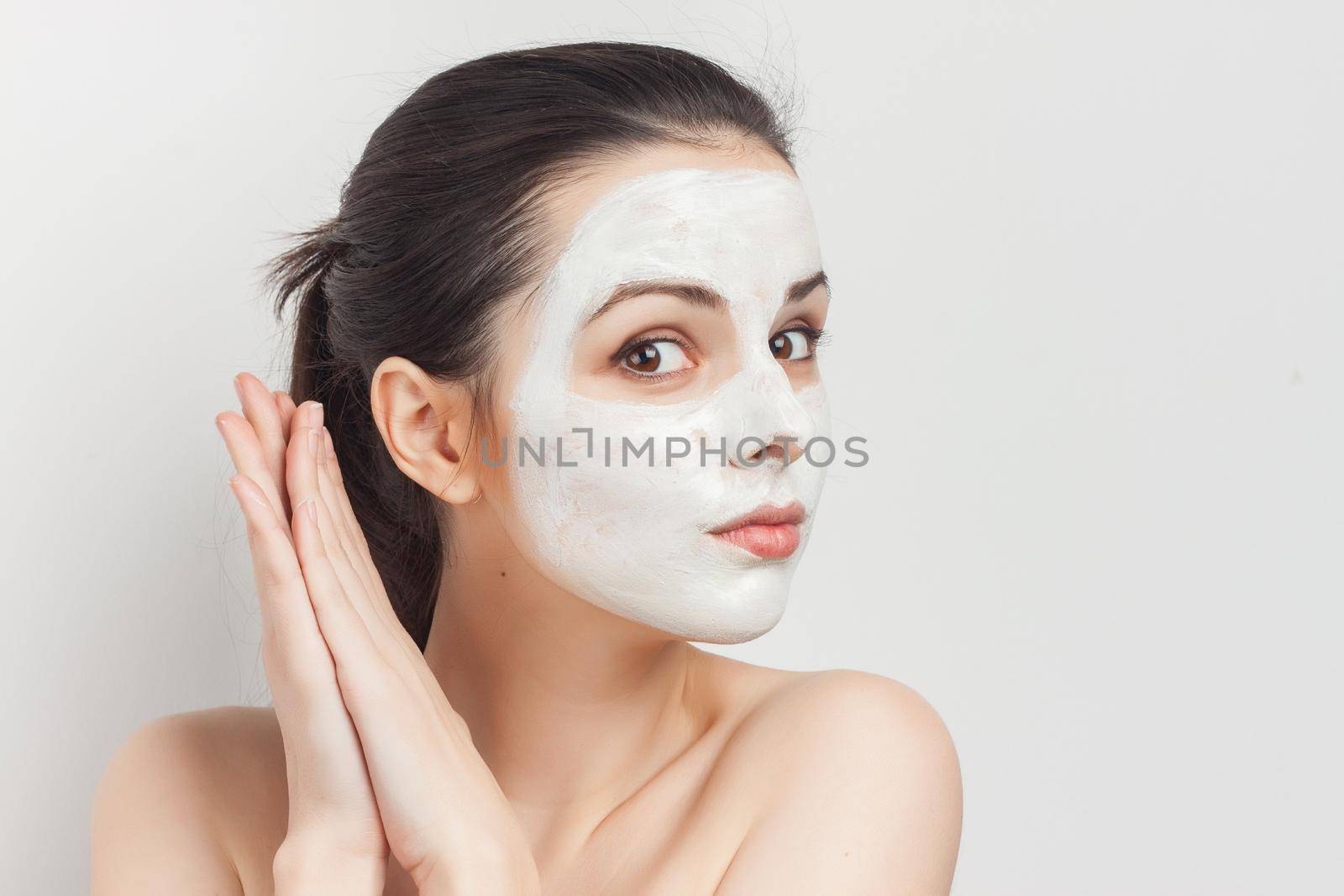pretty brunette with bare shoulders gathered hair mask facial cream. High quality photo