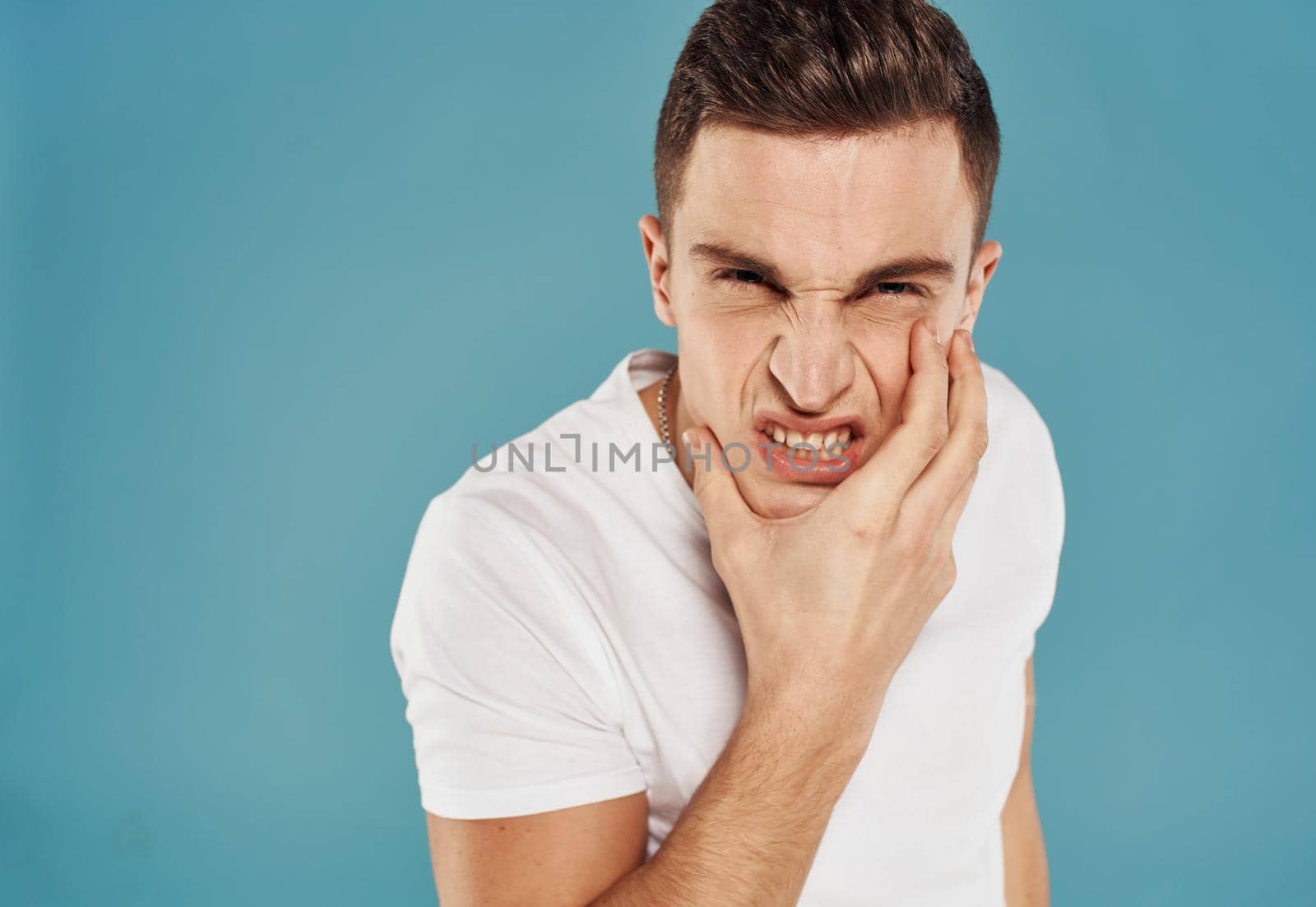 Man in white t-shirt emotions angry look cropped view Studio. High quality photo