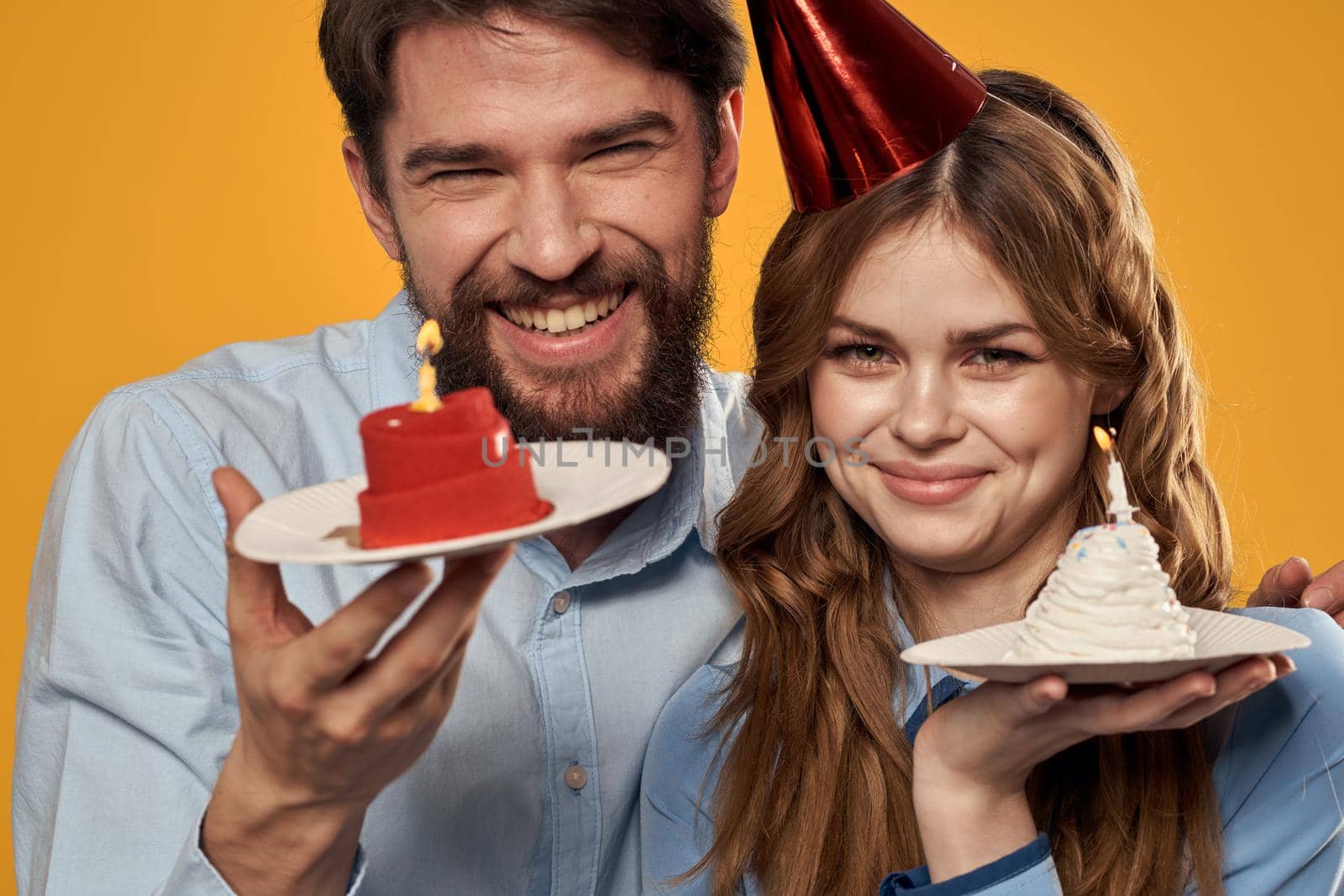 Birthday party man and woman fun yellow background cap holiday. High quality photo