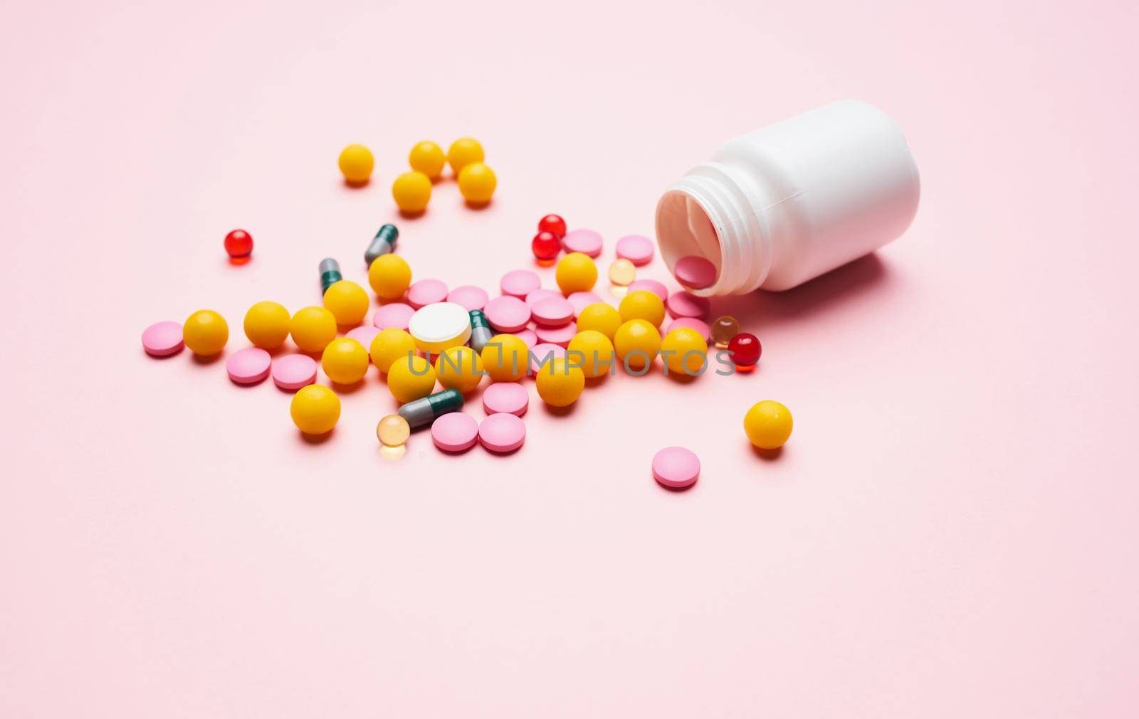 mountain multicolored pills first aid kit packaging pink health background. High quality photo