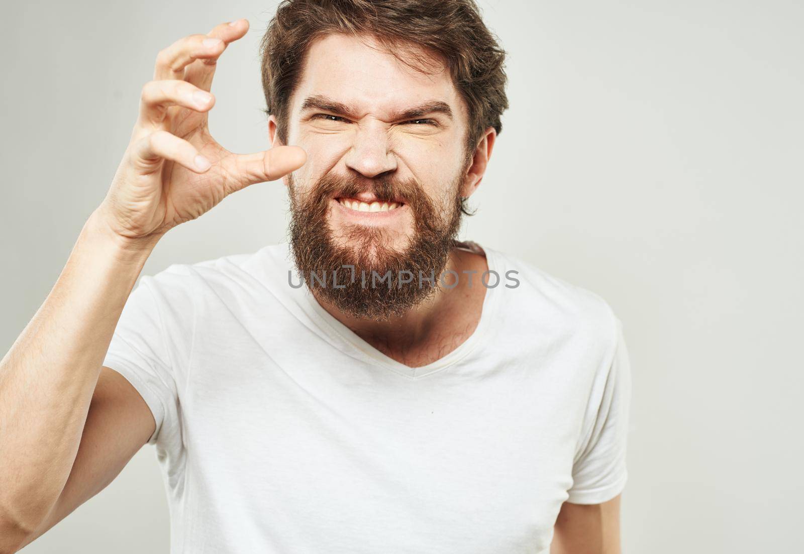 emotional man gesturing with his hands on a light background aggression scream. High quality photo
