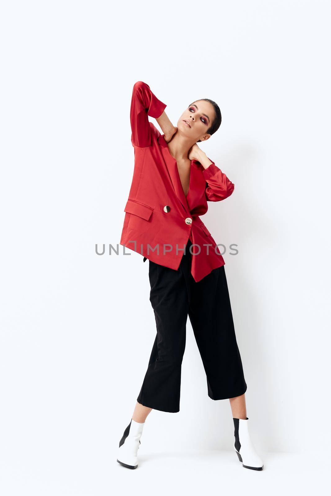 attractive woman in red jacket fashion bright makeup posing light background. High quality photo