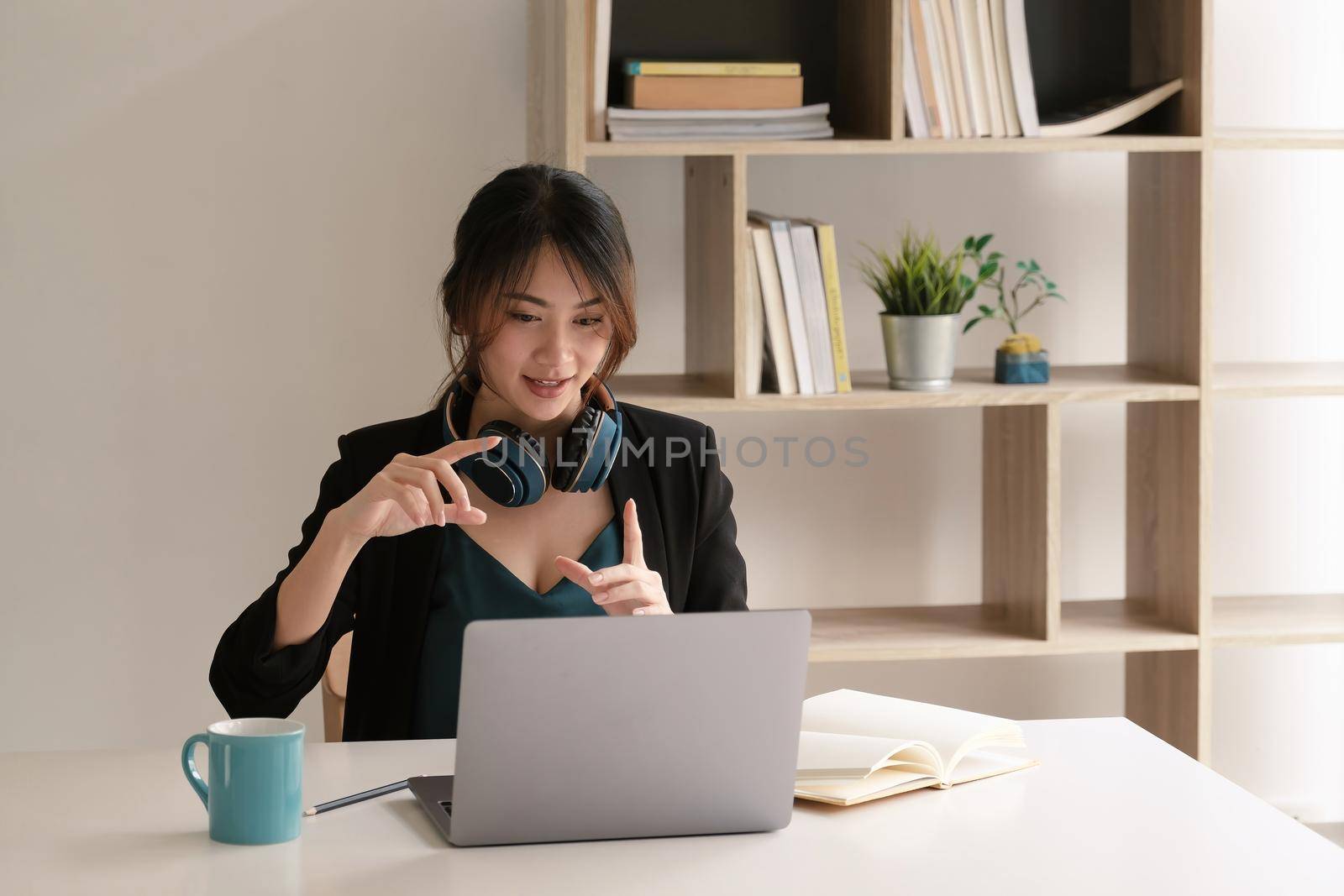 Asian student remote teacher tutor wear headphones video conference calling online, learning remote class webcam lesson looking at laptop virtual meeting working at home office.