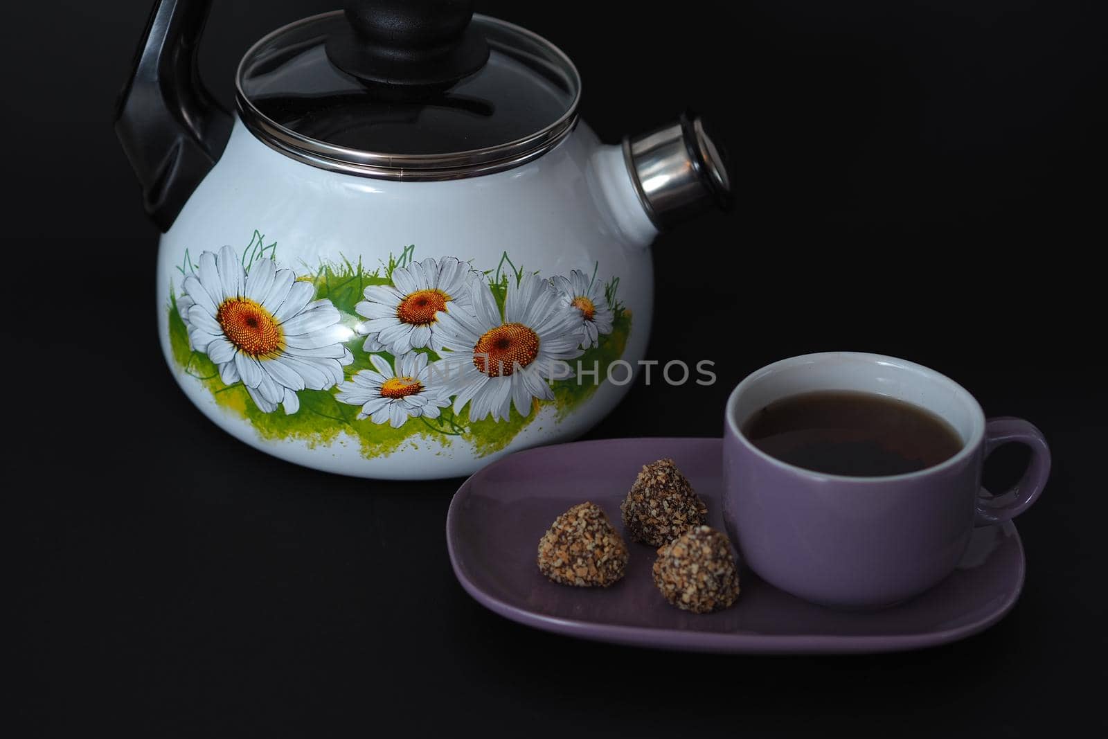 Beautiful enamelled kettle with a whistle on a black background. by Olga26