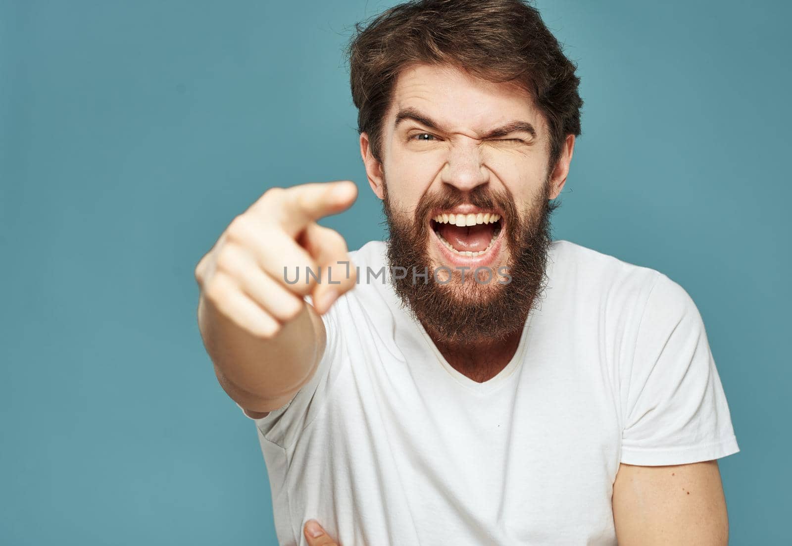 joyful man touching his head with his hands happiness emotions blue background. High quality photo
