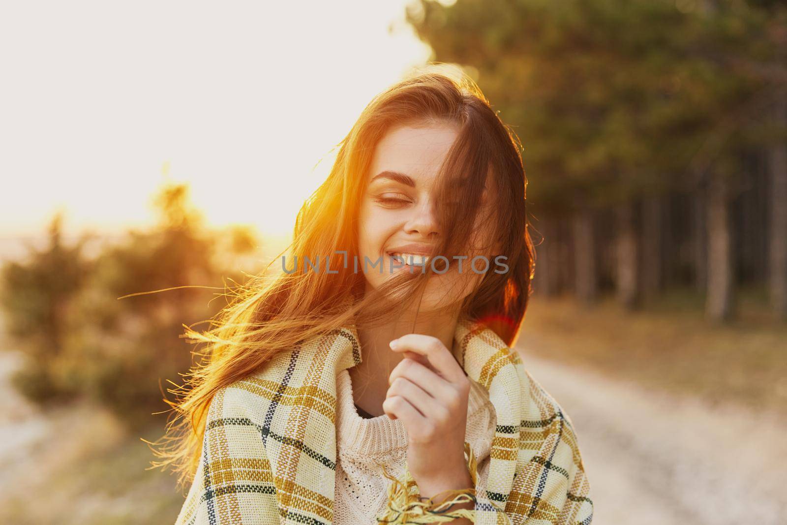 Woman at sunset coniferous forest checkered plaid model. High quality photo