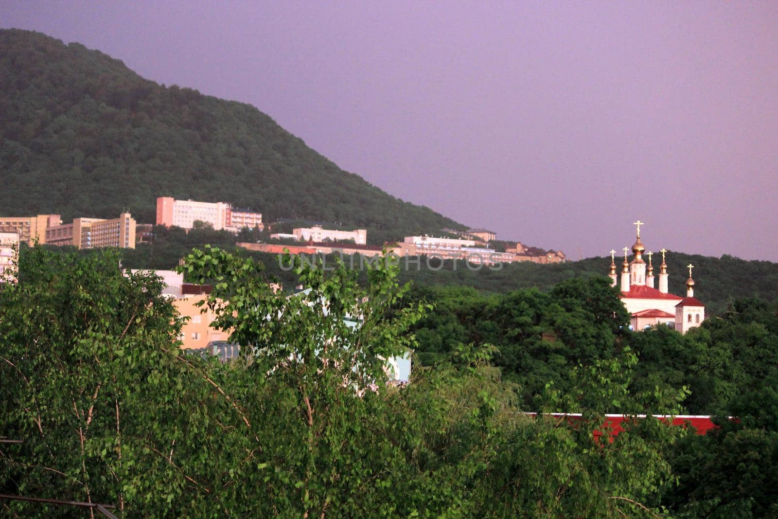 Rainbow over the city at sunset. Mountain landscape with a rainbow. by Olga26