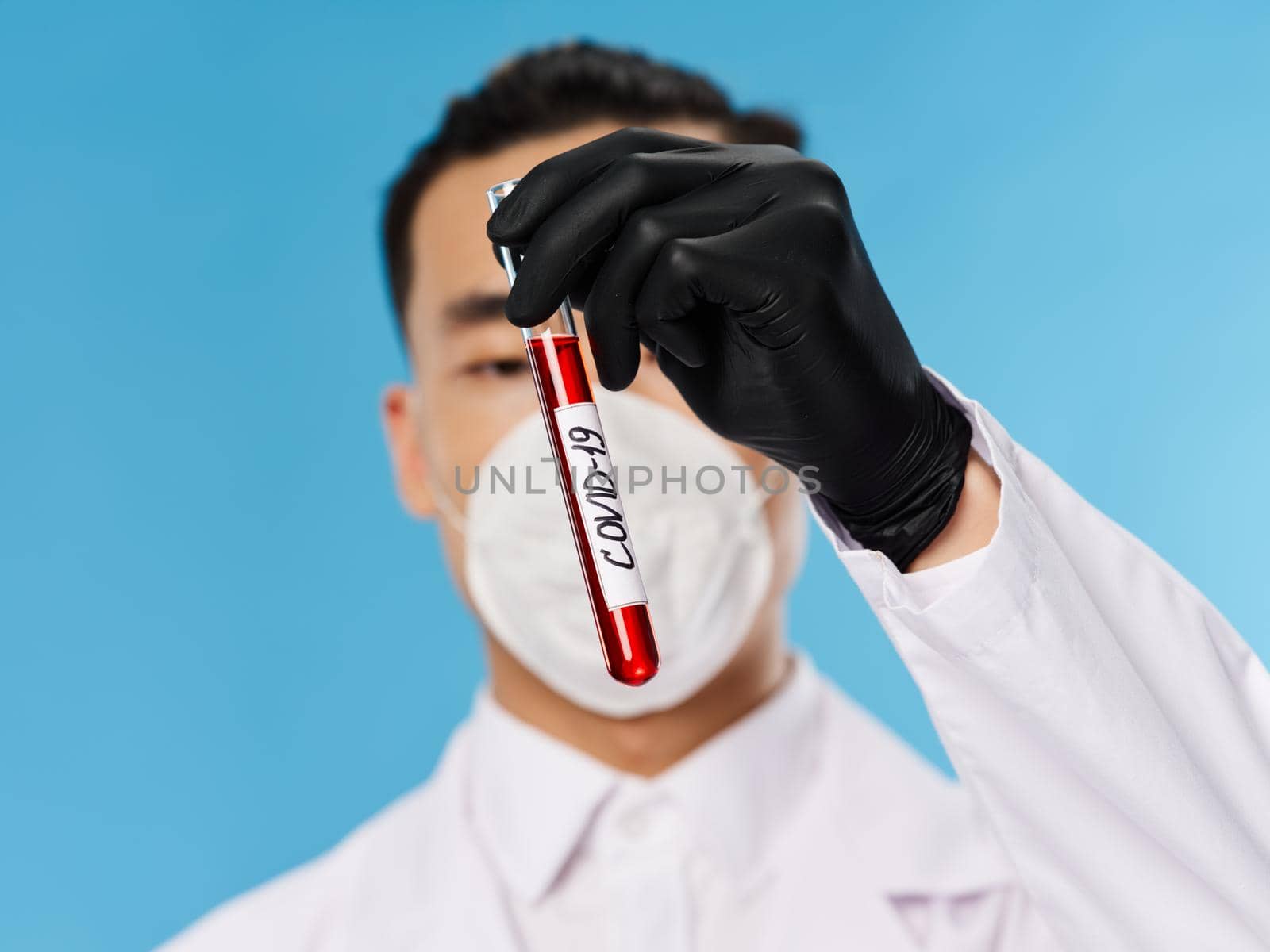 laboratory assistant asian looking medical mask analyzes examination science blue background. High quality photo