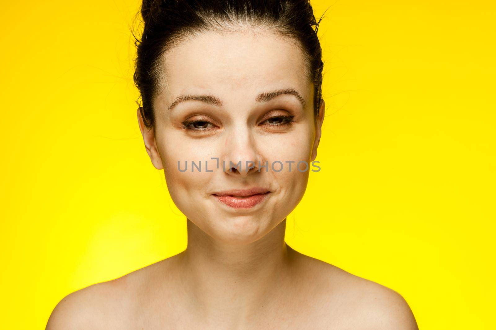 pretty woman naked shoulders smile clear skin yellow background. High quality photo
