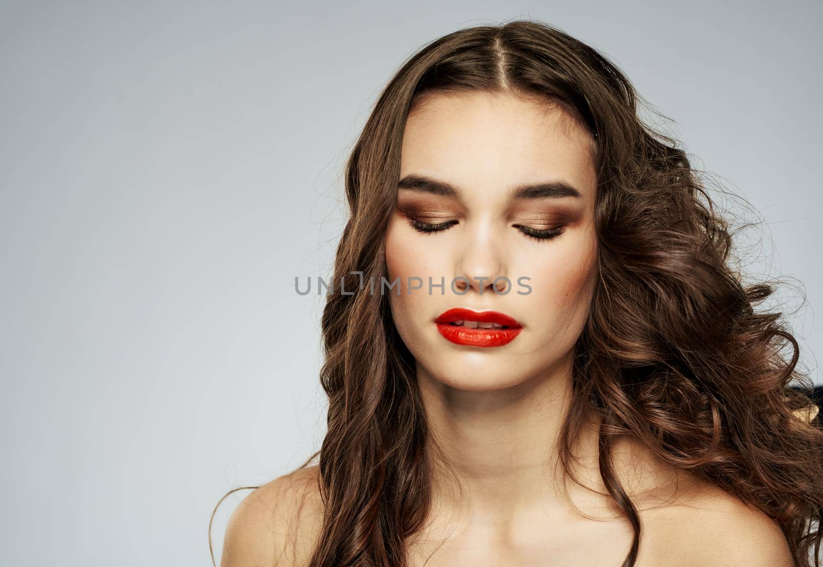 Beautiful woman with wavy hair on a light background hairdresser hairstyle model. High quality photo