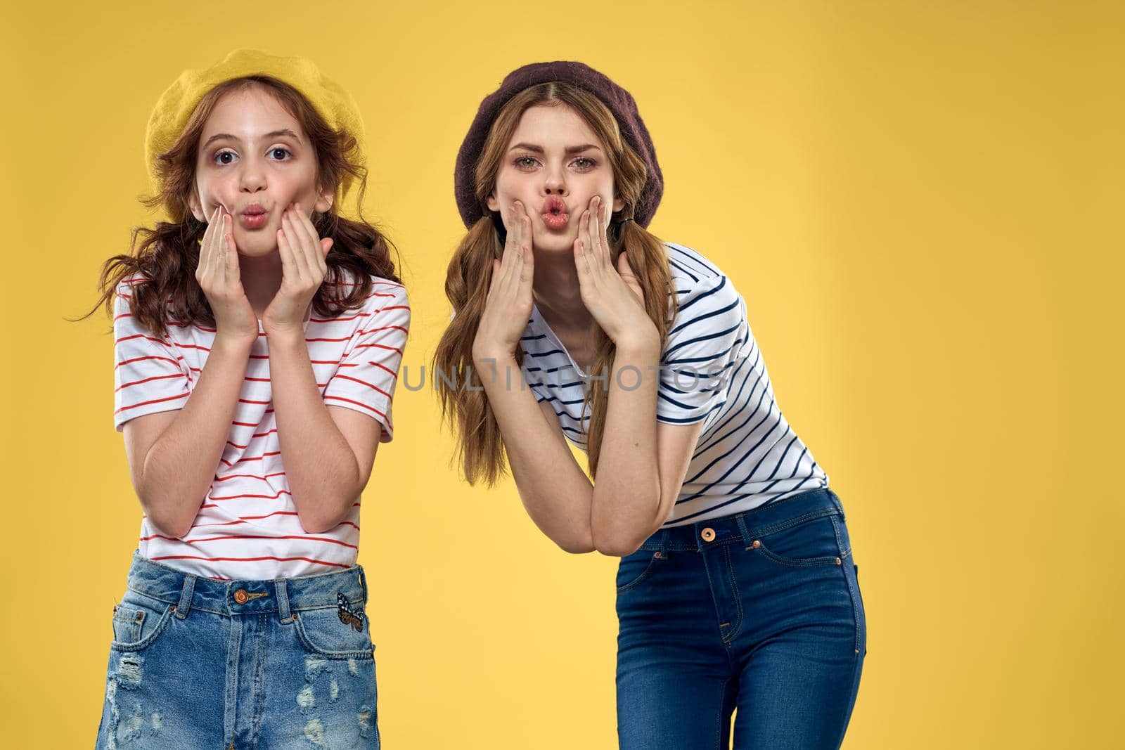 funny mom and daughter fashion clothes studio lifestyle yellow background. High quality photo