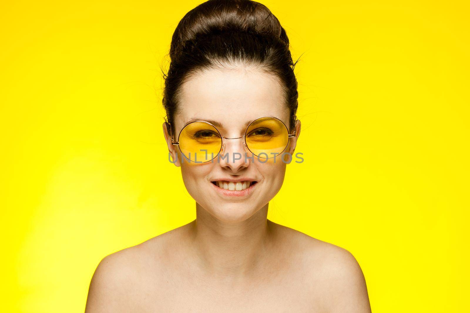 woman with bare shoulders yellow glasses isolated background. High quality photo