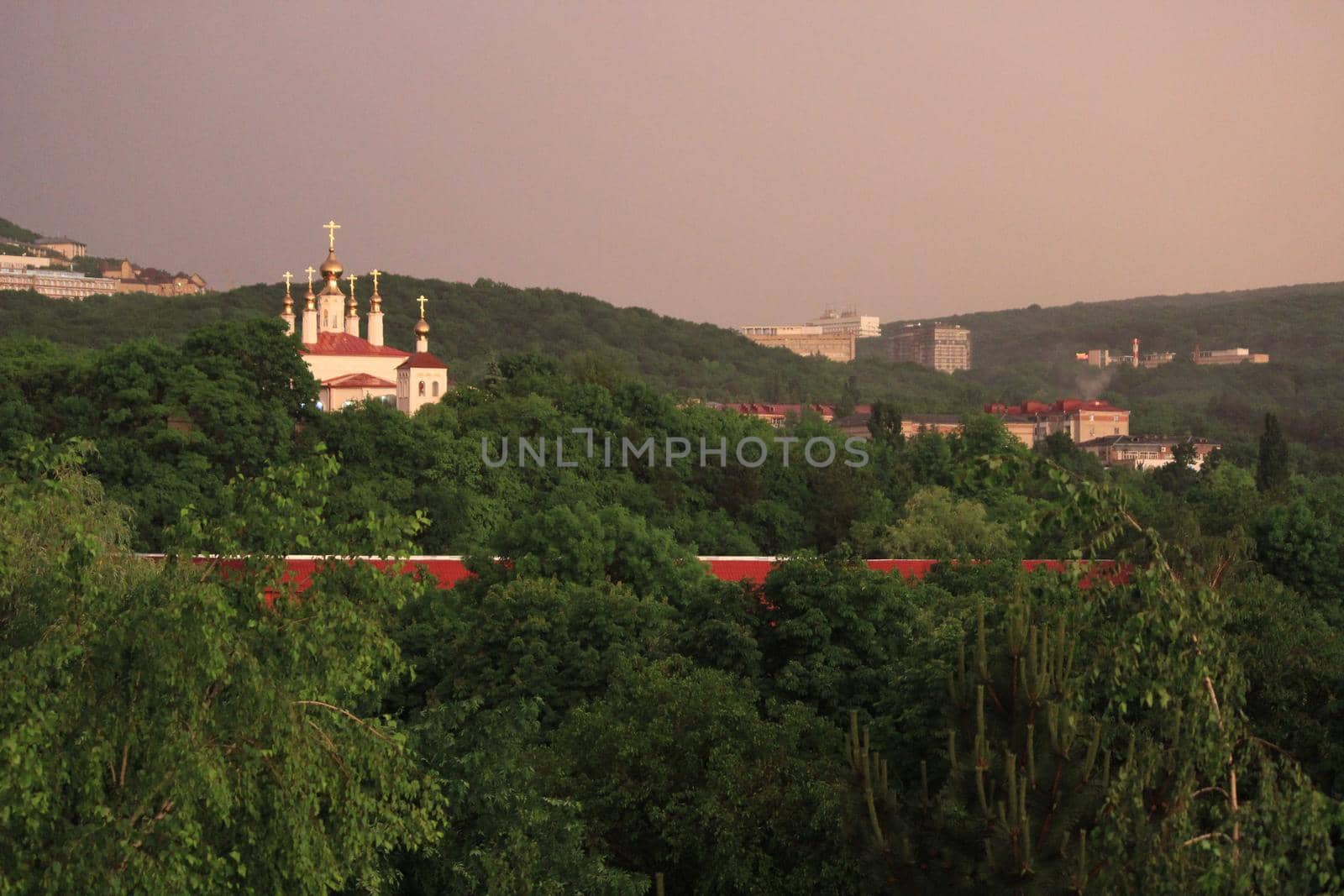 Rainbow over the city at sunset. Mountain landscape with a rainbow. Vertical image.