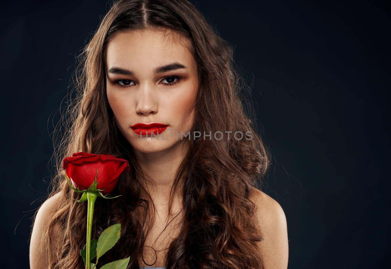 Romantic woman on a black background with a red flower. High quality photo