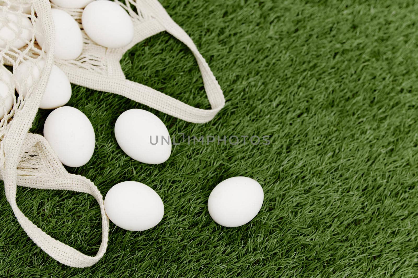 white eggs in a bag lie on the lawn top view Spring holiday Easter. High quality photo