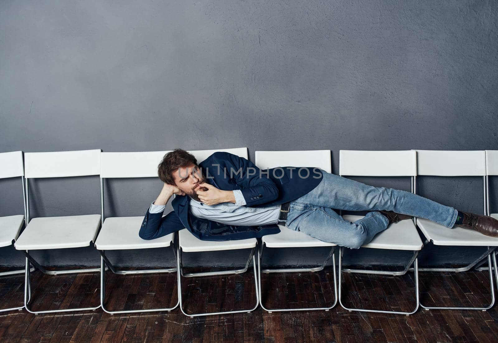 man lying on white chairs work emotions dismissal professional. High quality photo