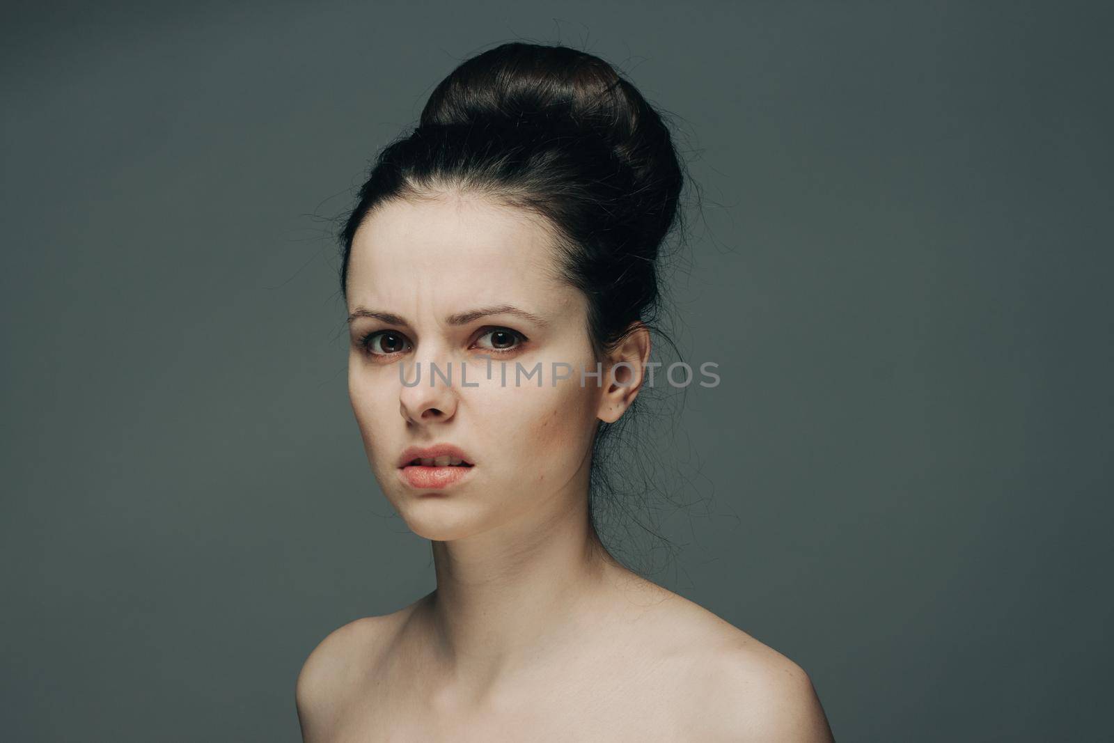 beautiful brunette with bare shoulders on gray background cropped view. High quality photo
