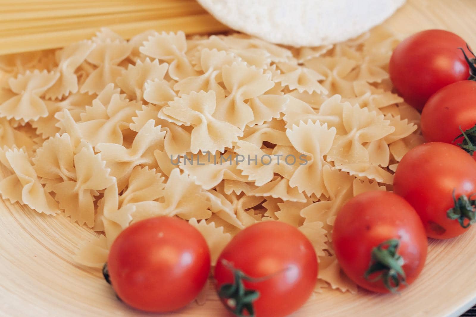 Italian pasta kitchen cooking wood table ingredients cherry tomatoes. High quality photo
