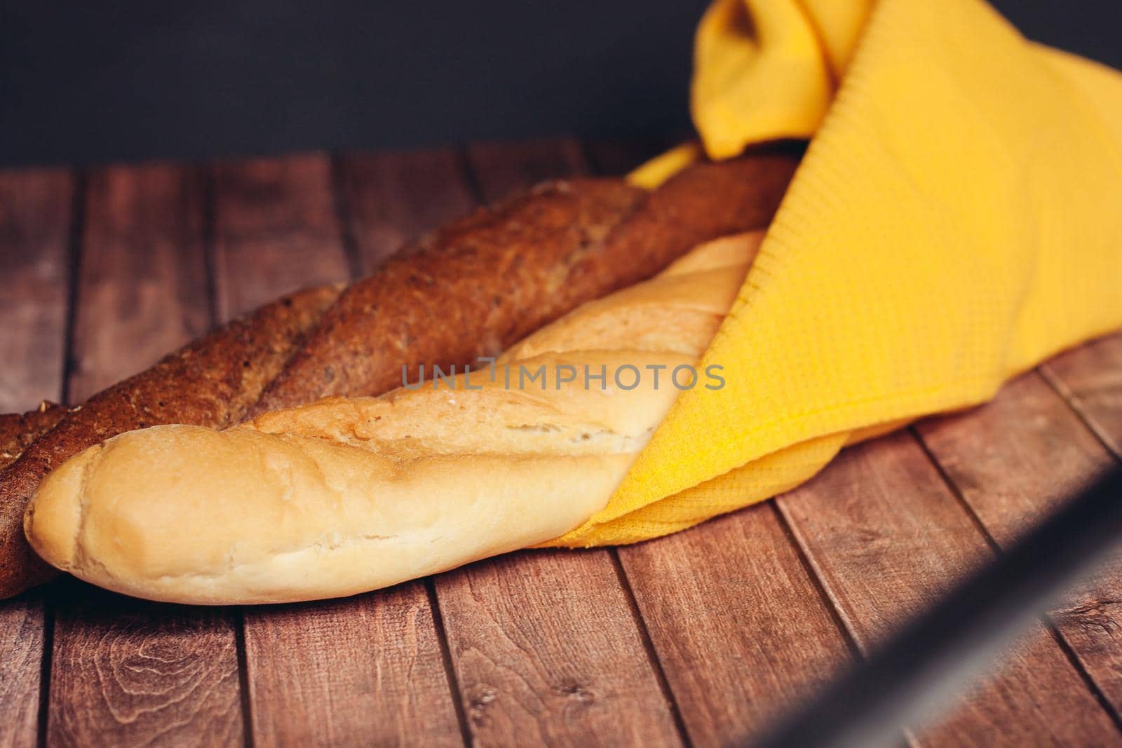 fresh sliced loaf yellow napkin wooden table baked goods. High quality photo